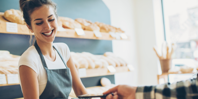 Woman in bakery accepting payment on card